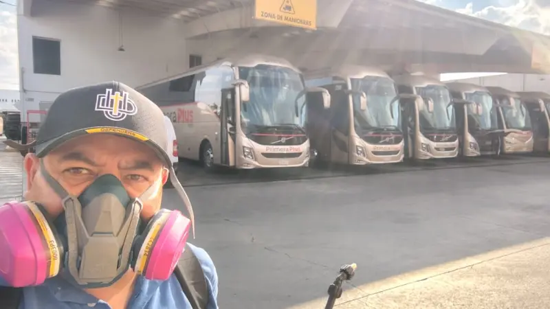 Fumigador en estación de autobuses mostrando un grupo de camiones estacionados